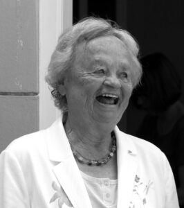 Schwarzweiß-Bild einer älteren Frau, die fröhlich lacht. 